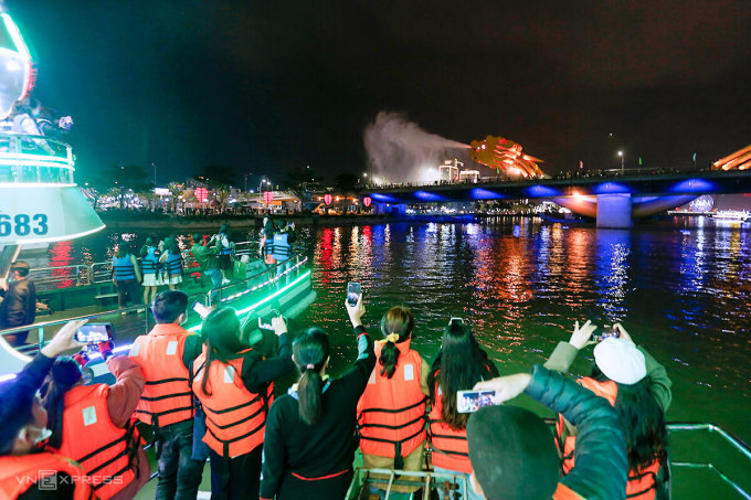 Du khách trải nghiệm đi du thuyền ngắm sông Hàn và cầu Rồng phun lửa, nước, dịp Tết 2021. Ảnh: Nguyễn Đông.