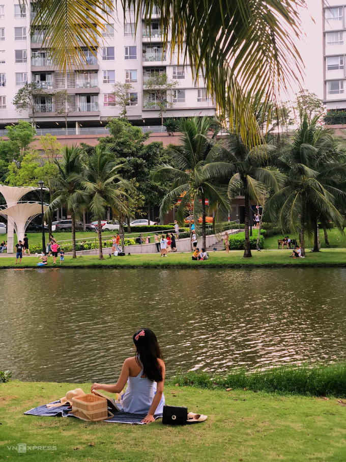 Góc chụp được nhiều bạn trẻ lựa chọn là ngồi trên thảm cỏ xanh cạnh hồ nước hoặc dựa vào gốc cây dừa cảnh. Ảnh: Ngân Dương