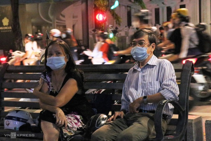 Vợ chồng chú Thạnh, cô Hoa ngồi ở phố đi bộ Nguyễn Huệ tối 10/10. Ảnh: Huỳnh Nhi