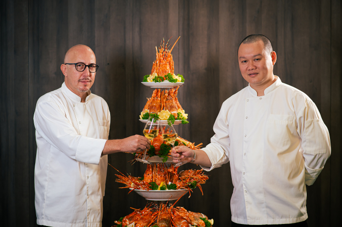Bếp trưởng Markus Fisler (bên trái) và bếp trưởng Nguyễn Gia Thiện (bên phải) bên cạnh tháp hải sản đặc biệt trên du thuyền Ambassador.