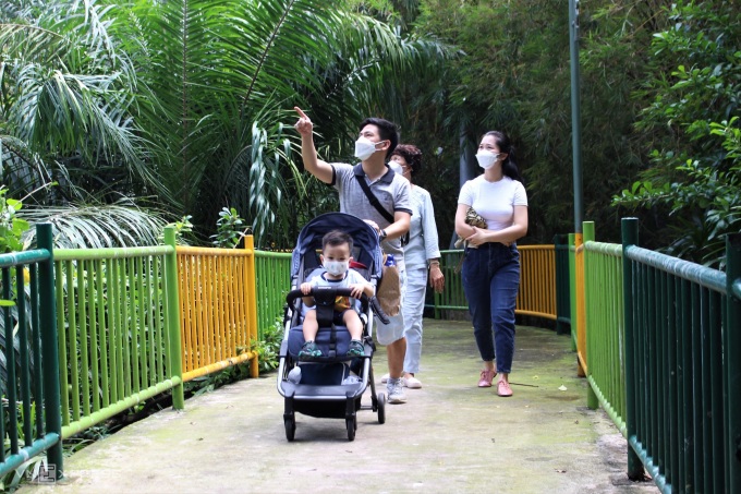 Gia đình anh Hưng, quận 7 dẫn con 2 tuổi đi tham quan công viên Đầm Sen. Anh yên tâm dẫn trẻ nhỏ theo vì công viên rộng và thoáng, gia đình đã tiêm đủ vaccine và tuân thủ 5K. Ảnh: Huỳnh Nhi